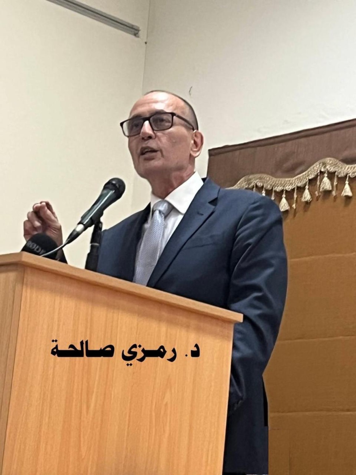 Dr. Ramzi Salha speaking at a lectern